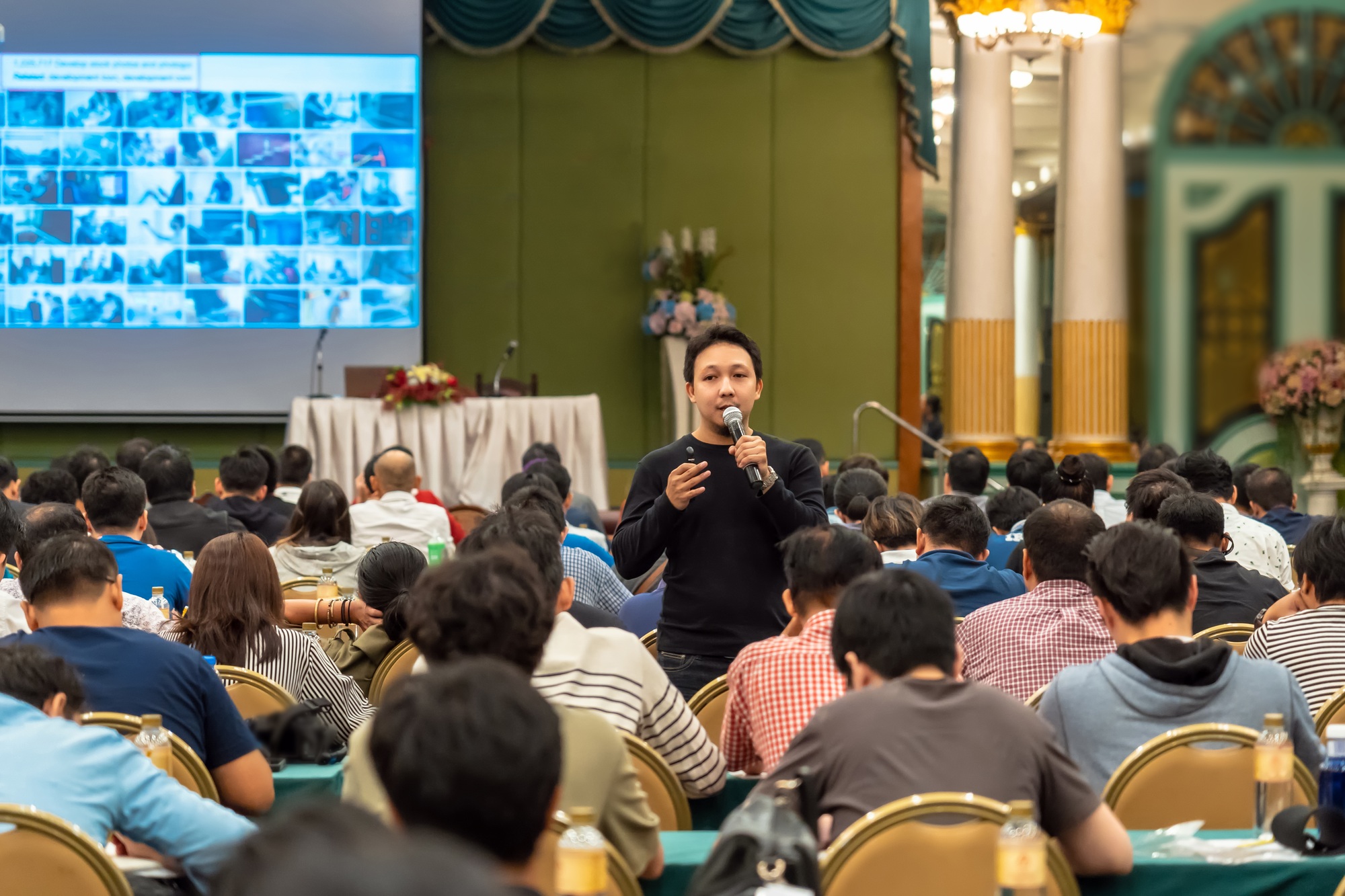 Asian Speaker with casual suit standing and giving the knowledge with audience in conference hall